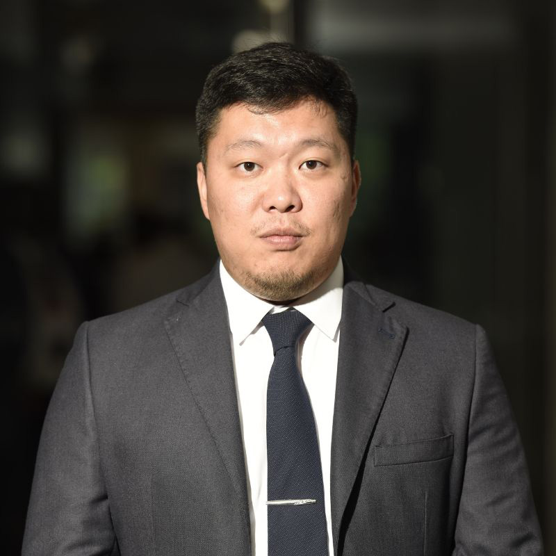 Asian man in gray suit with gray tie